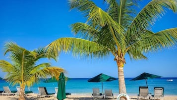 On the beach, white sand, sun loungers, beach umbrellas