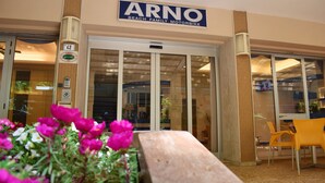 Entrada de un edificio con un cartel que dice "ARNO BEACH FAMILY MOTORBIKE".