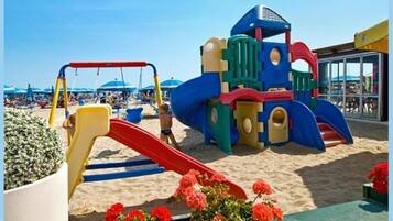 Children can play and explore the beachside playground with a slide and climbing elements.
