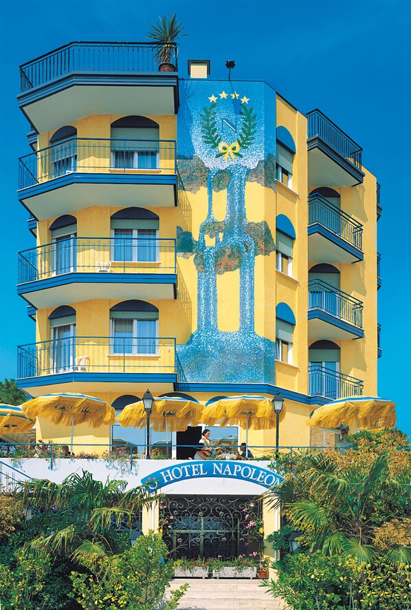 A multi-story hotel with balconies, a prominent mural, and a sign reading "HOTEL NAPOLEON". - Hotel Napoleon (Jesolo)