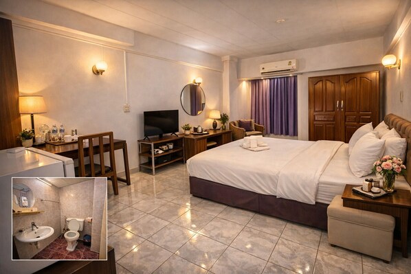 A hotel room with a bed, TV, desk, and bathroom.