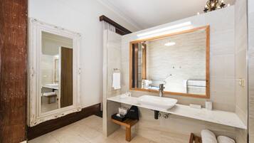 Un bagno moderno con uno specchio grande, un lavandino bianco e una panca in legno.