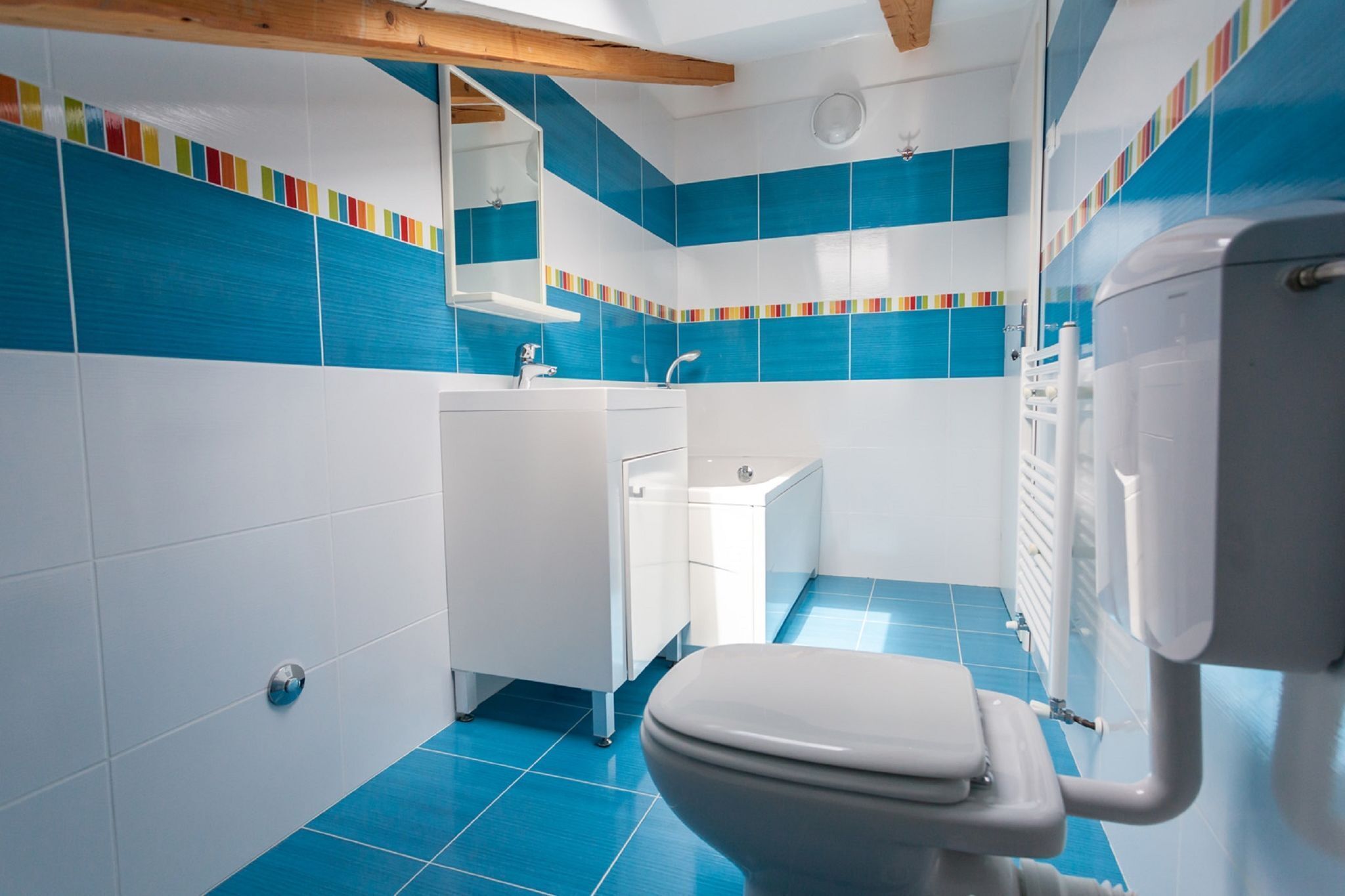 Un baño con inodoro, lavabo y zona de ducha.