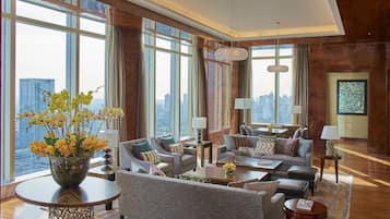 A spacious living room with large windows, a city view, and modern furniture.