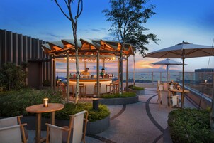 Una piscina al aire libre, sombrillas, sillones reclinables de piscina