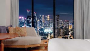 A modern hotel room with a large window offering a nighttime cityscape view. - ANDAZ SINGAPORE, BY HYATT (Singapore)