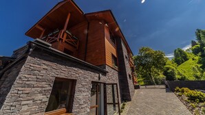 Et moderne hus med en stenfacade og en træbeklædt øvre del.