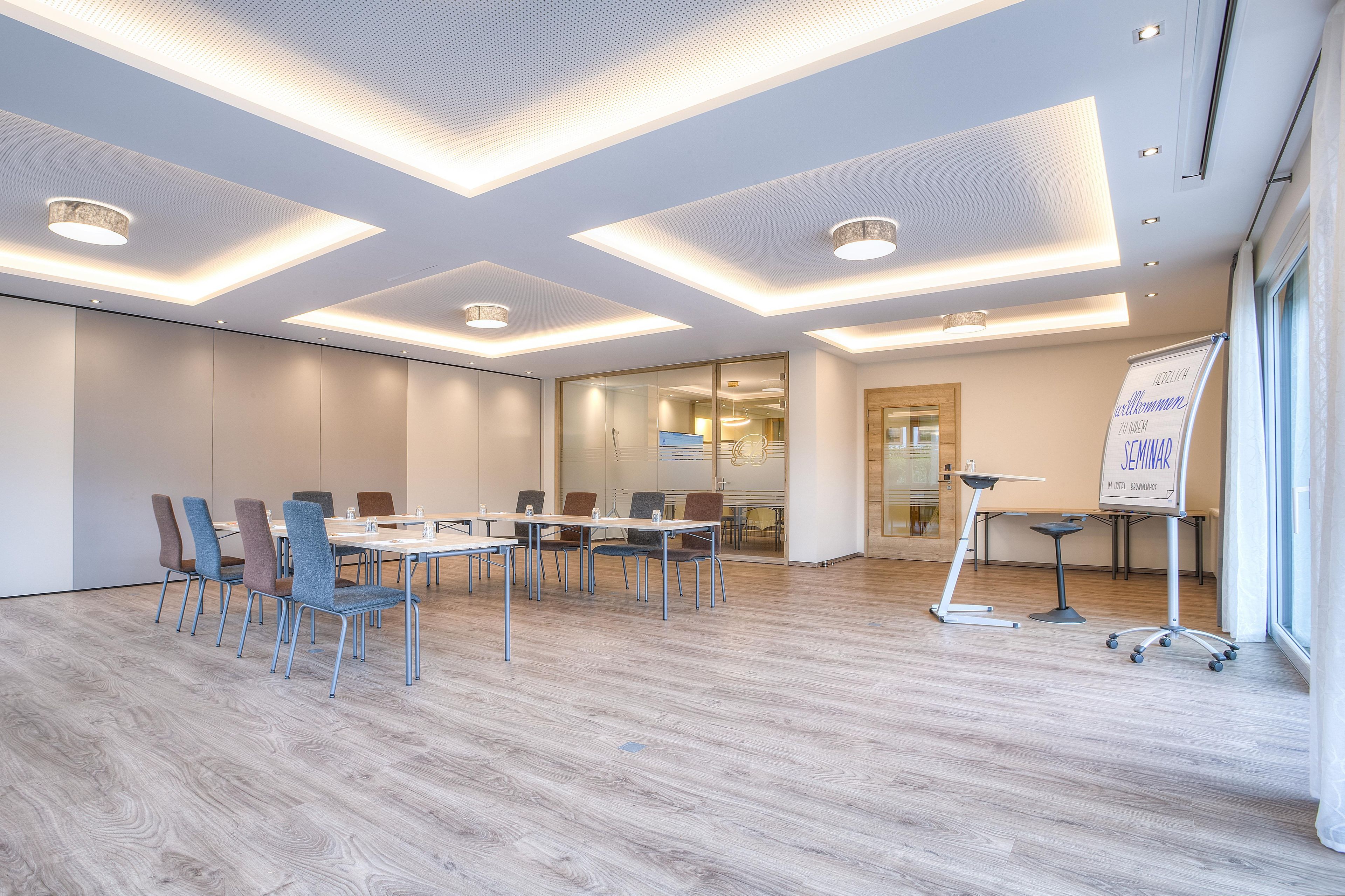 A modern conference room with a whiteboard, meeting tables, and chairs.