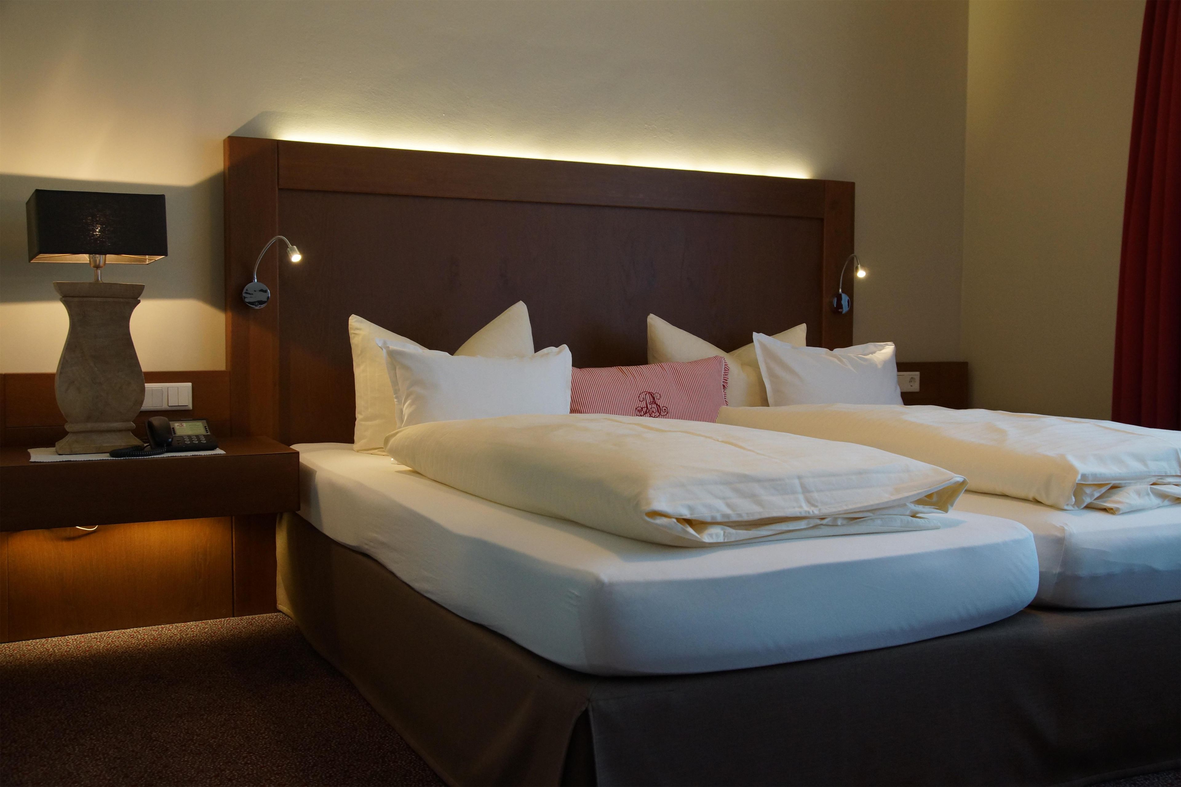 A hotel room with a double bed, two bedside tables, a lamp, and a telephone.