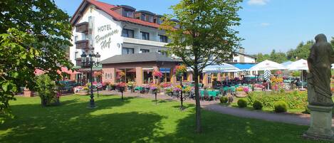 Un hotel amb teulada vermella i un rètol que diu "HOTEL Brunnenhof".