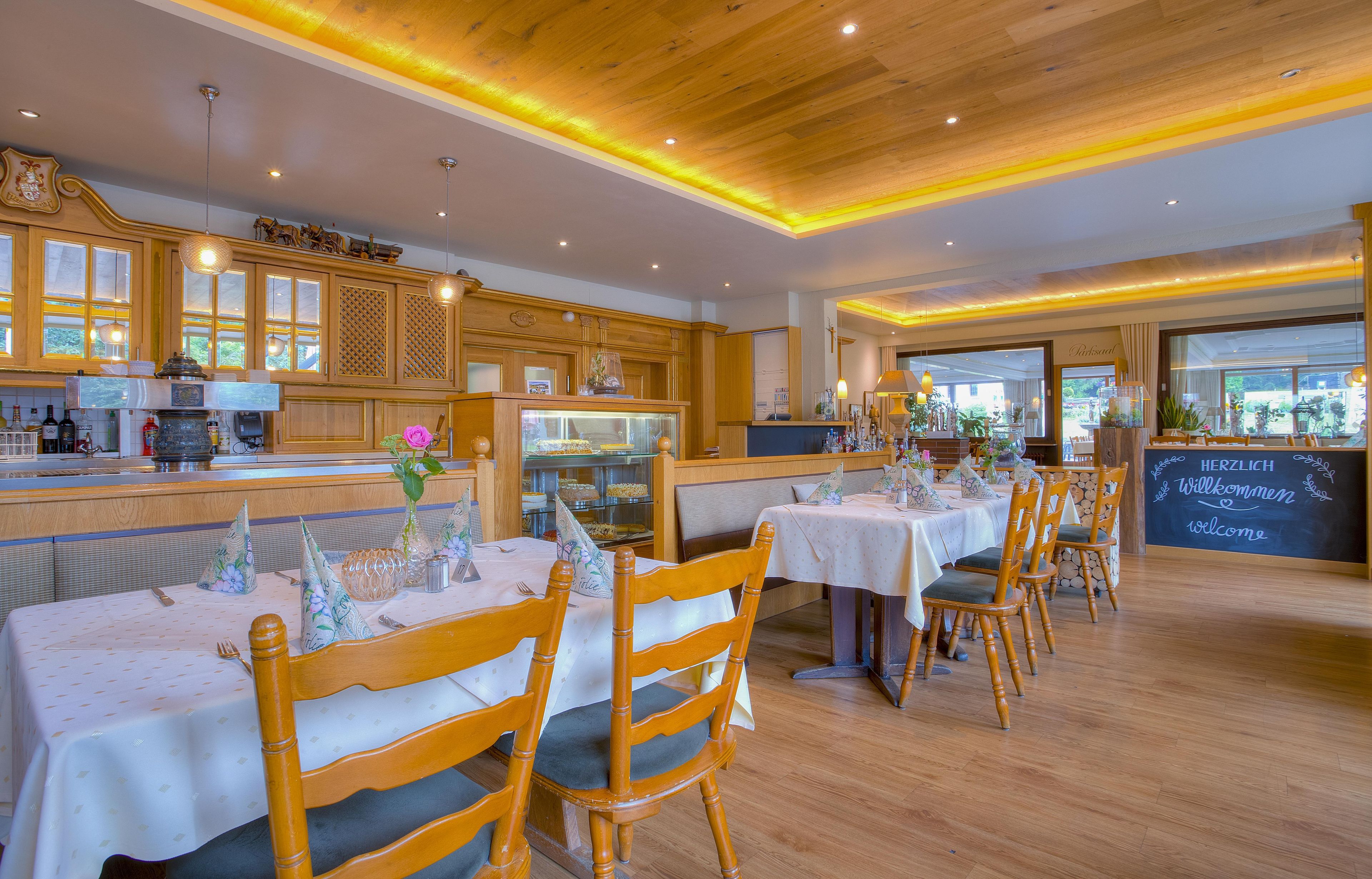 A restaurant with wooden furniture, a bar area, and a view of the outdoors.