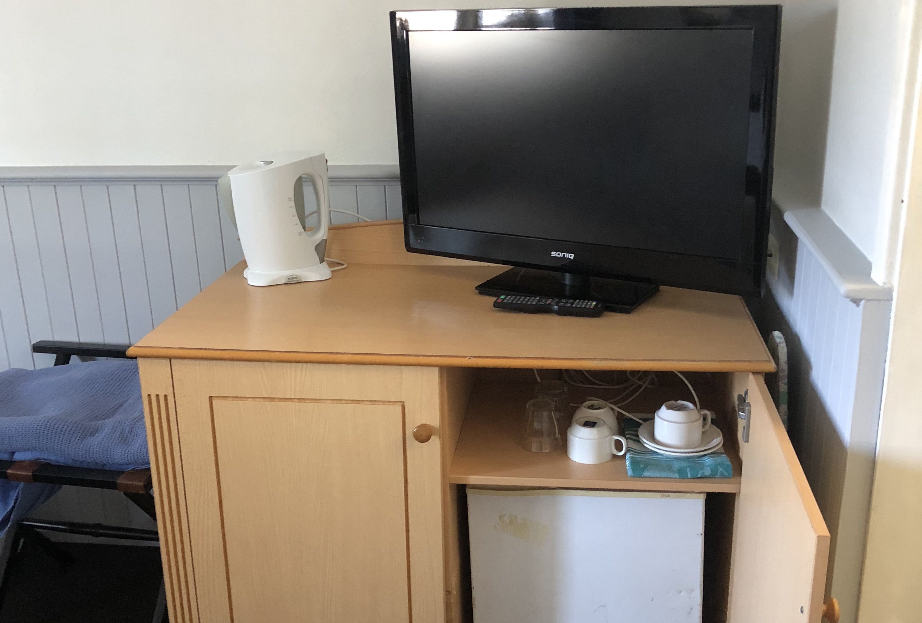 Una piccola cucina accessoriata con una TV nera, una macchina del caffè e un forno a microonde.