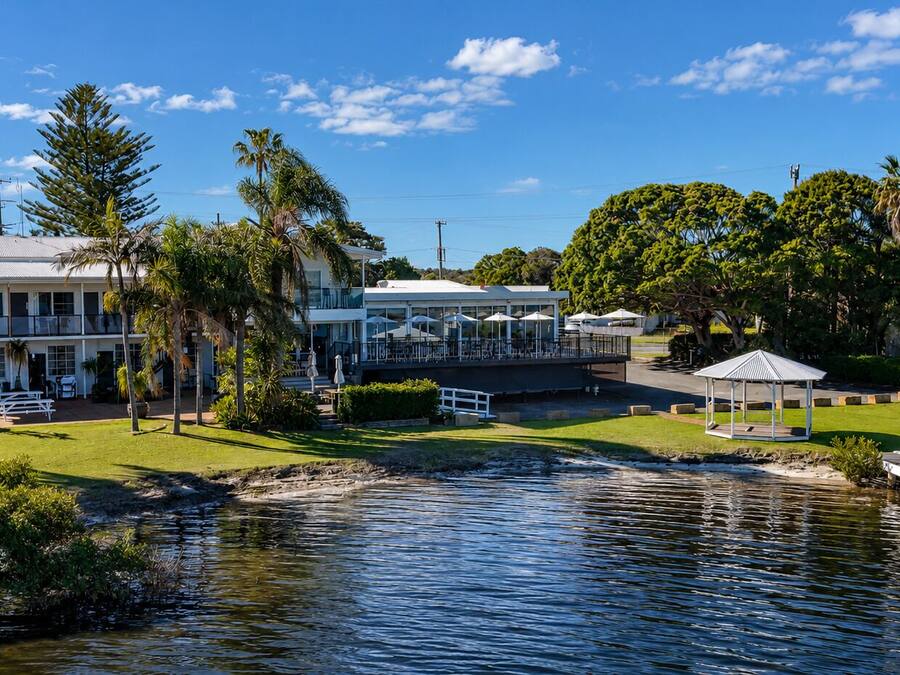 A waterfront property with a dining area, outdoor seating, and a gazebo.