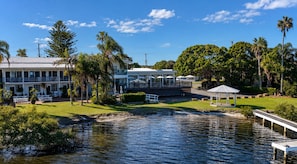 A waterfront property with a dining area, outdoor seating, and a gazebo.