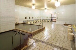 A public bath area with multiple changing rooms, a large pool, and a shower area. - Frontier Sunrise (Kamifurano)