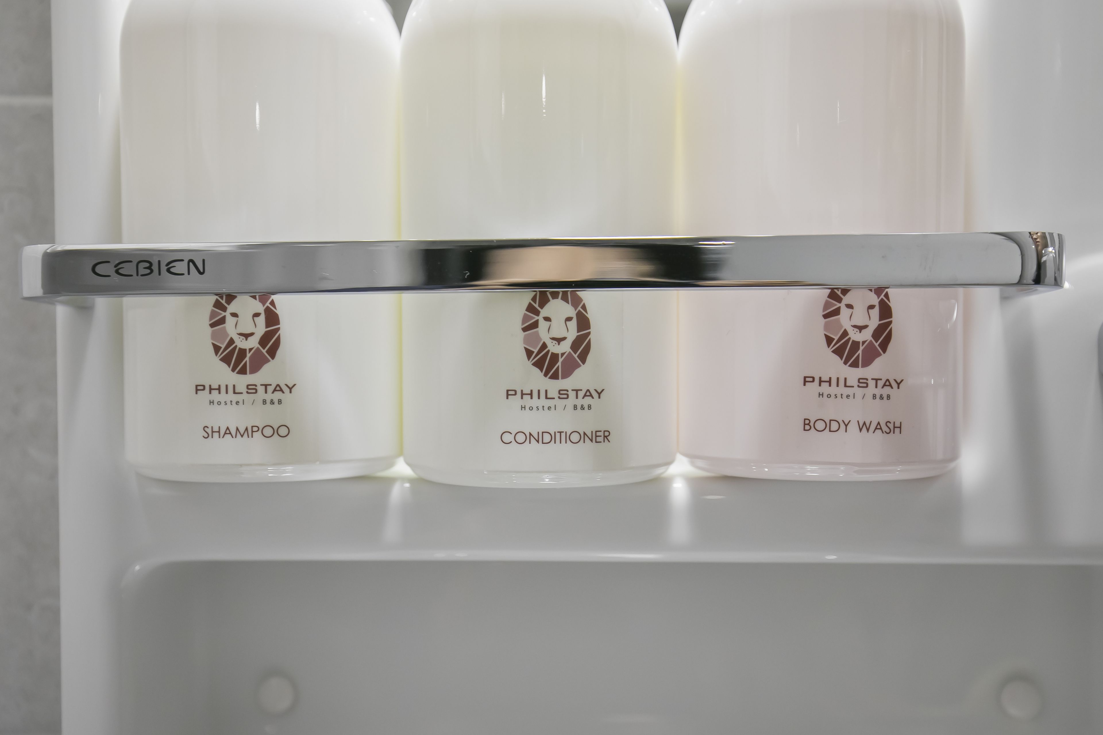 Tre prodotti Philstay disposti su uno scaffale: shampoo, balsamo e bagnoschiuma.