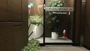 Entrada de ascensor con un cartel que dice "PHILSTAY Myong-dong Station".