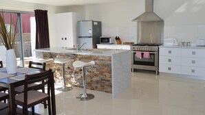 Una cucina moderna con isola centrale, elettrodomestici in acciaio inossidabile e una cappa aspirante di grandi dimensioni.