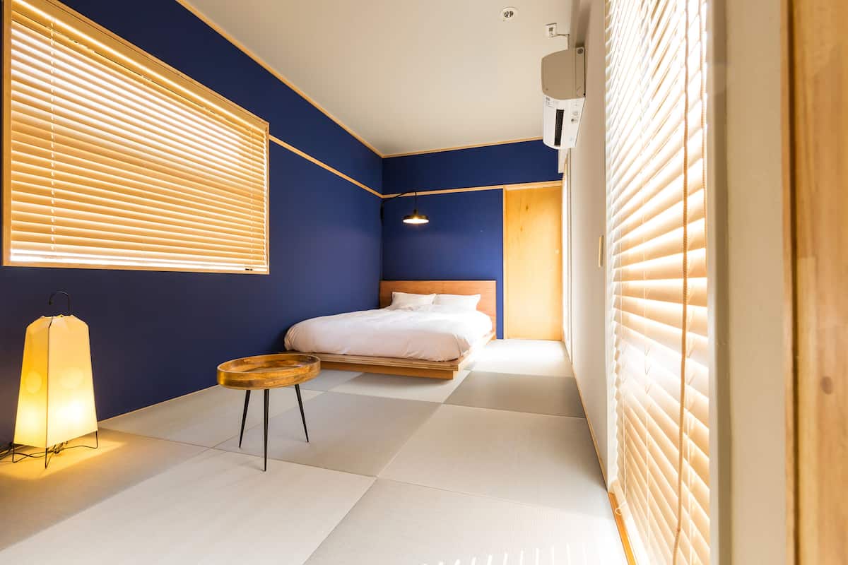 Ein Schlafzimmer mit einem Bett, einem Nachttisch und einer Stehlampe.