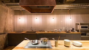 Une cuisine moderne dotée d’un plan de travail en bois, d’appareils électroménagers en acier inoxydable et d’une hotte de cuisinière en cuivre.