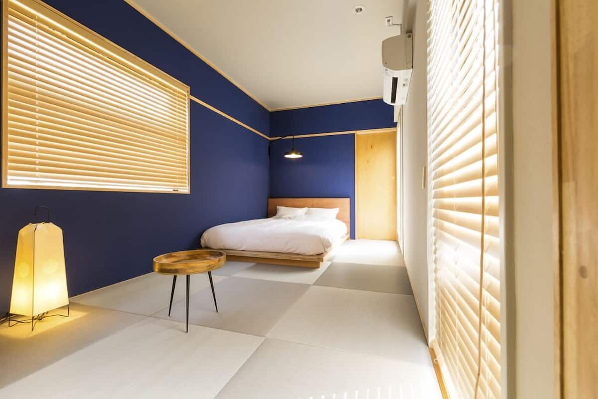 A modern bedroom with a bed, bedside table, and a lamp.