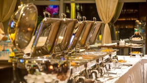 A buffet setup with multiple serving stations, including various food items and utensils. - Premium Hotel Ulaanbaatar (Ulaanbaatar)