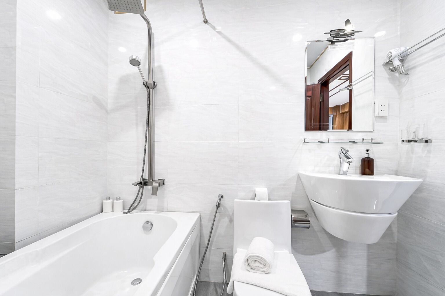 A modern bathroom with a white bathtub, a sink, and a shower.