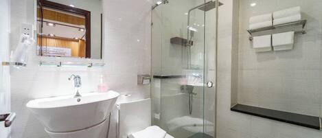 A modern bathroom with a glass-enclosed shower, a white sink, and a toilet.