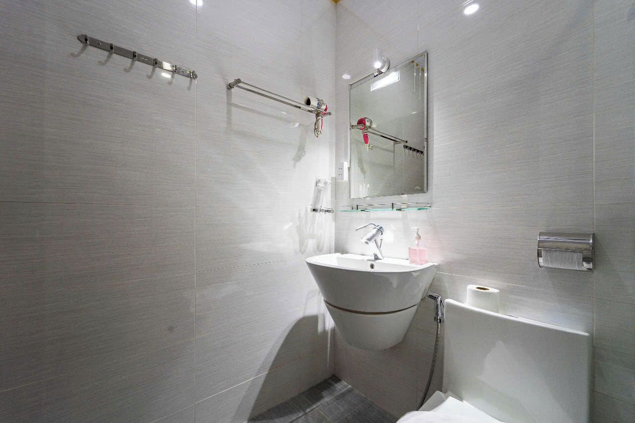 A modern bathroom with a freestanding bathtub, a sink with a mirror above it, and a towel rack on the wall.