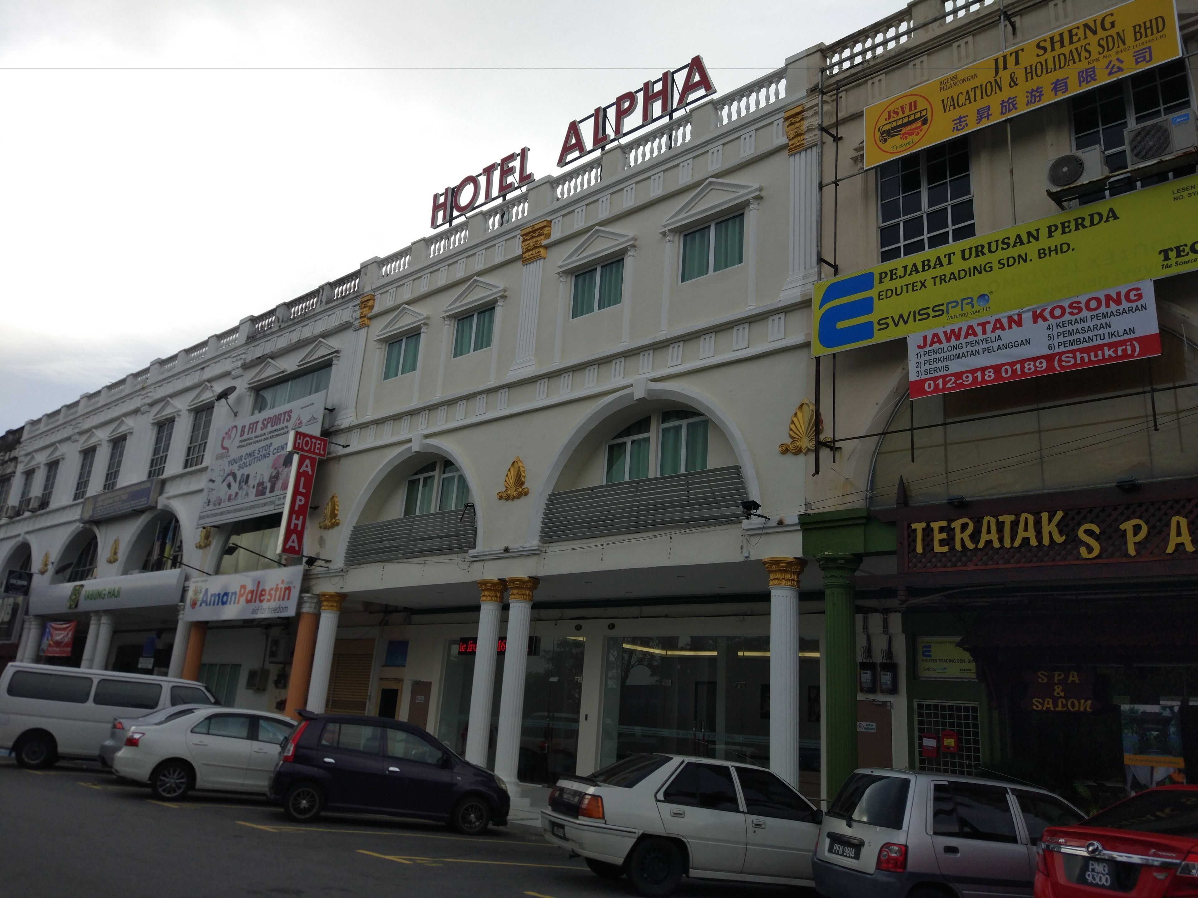 A multi-story building with a prominent sign for Hotel Alpha.