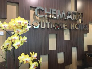 A reception desk with a sign for 'CHEMARA Boutique Hotel'.