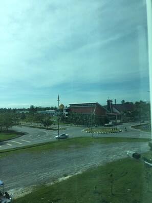 A view of a roundabout with a church and a modern building in the background.