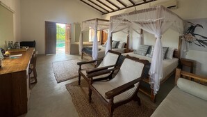 Una habitación con techo de madera, una cama con dosel, una silla y una mesa con bandeja.