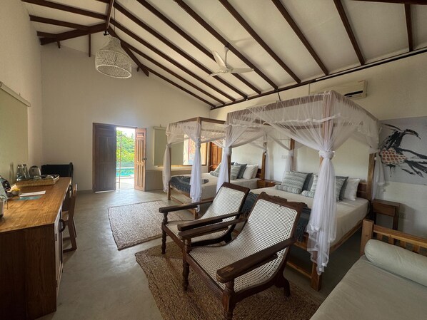 Una habitación con techo de madera, una cama con dosel, una silla y una mesa con bandeja.