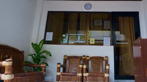A wooden ceiling with a geometric pattern, a window with papers, and two wicker chairs. - AV Seven Resort (Boracay Island)