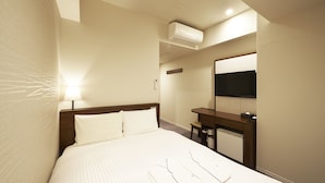 Une chambre d’hôtel comprenant un lit, une table de chevet, une lampe, un appareil de climatisation et un miroir.