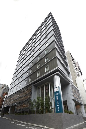 A tall, modern hotel with a distinctive facade and a prominent signage for the 'Suzuki Fresa Inn'.