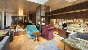 Un intérieur moderne avec des espaces aménagés pour s’asseoir, un bar et un présentoir à bouteilles.