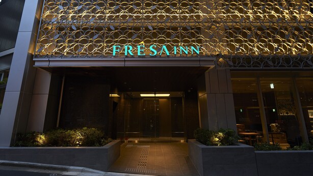 A hotel entrance with a decorative metal facade and the name 'FRESAIN' illuminated in neon lights. - Sotetsu Fresa Inn Tokyo Roppongi (Tokyo)