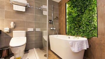 Une salle de bain moderne équipée de toilettes, d’une baignoire et d’une douche.