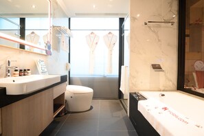 A modern bathroom with a large mirror, a white bathtub, and a toilet. - Hotel East Taipei (Taipei)