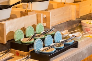 Een buffetopstelling met diverse gerechten en bestek.