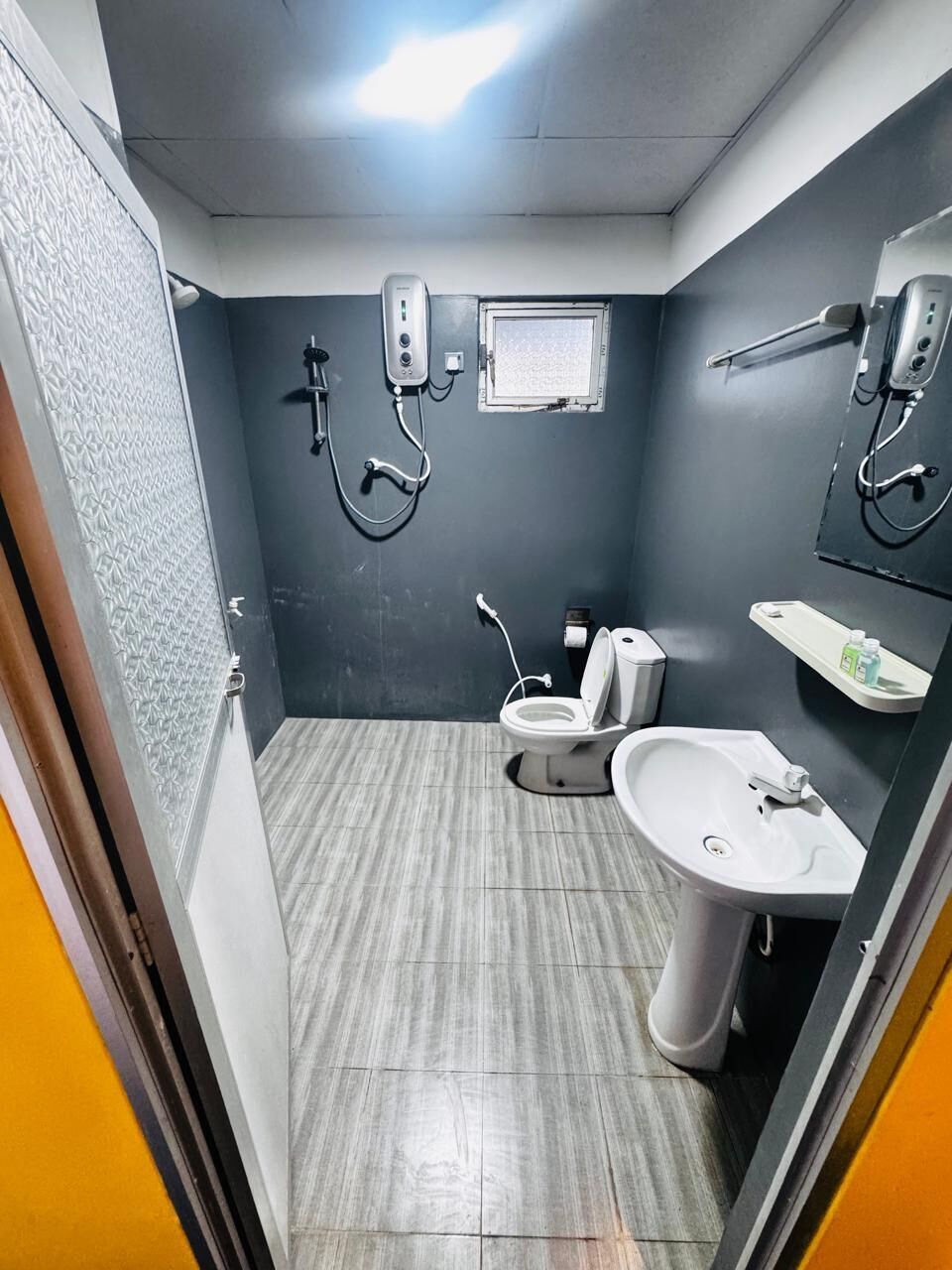 A compact bathroom with a toilet, bidet, and sink.