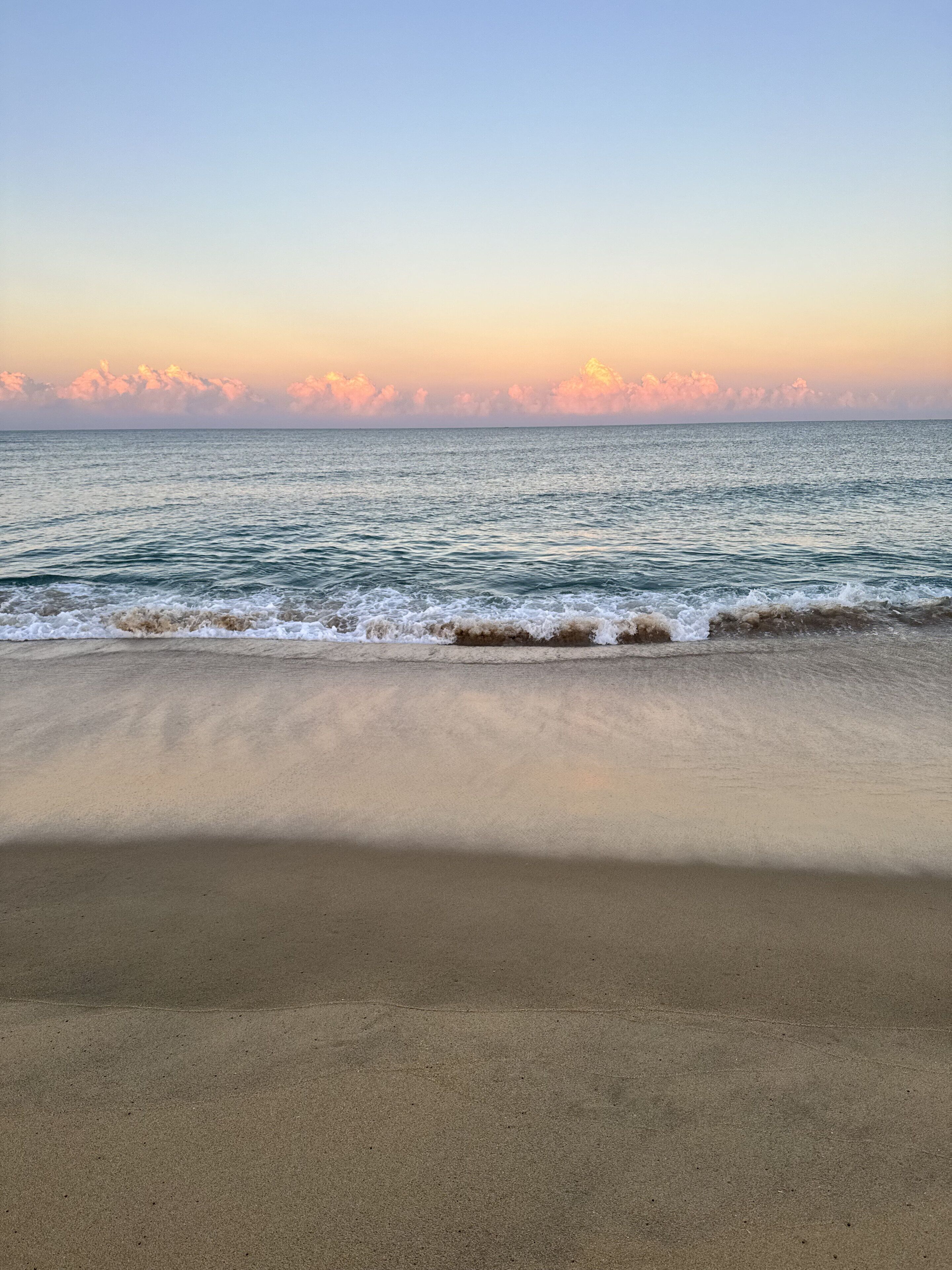 Una playa con mar tranquilo y cielo despejado.