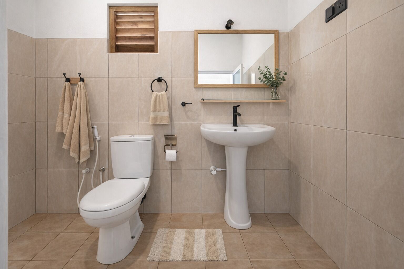 A bathroom with a toilet, sink, and a mirror.