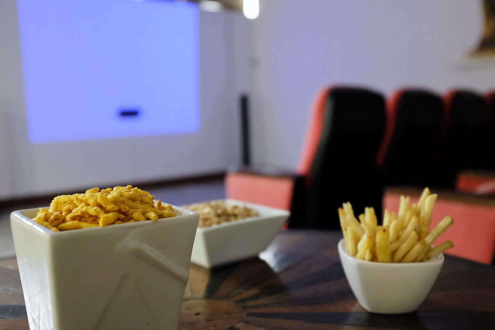 A table with two bowls of food and a projector screen in the background.
