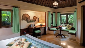 A bedroom with a bed, a desk, and a window seat. - Poppies Bali (Kuta)