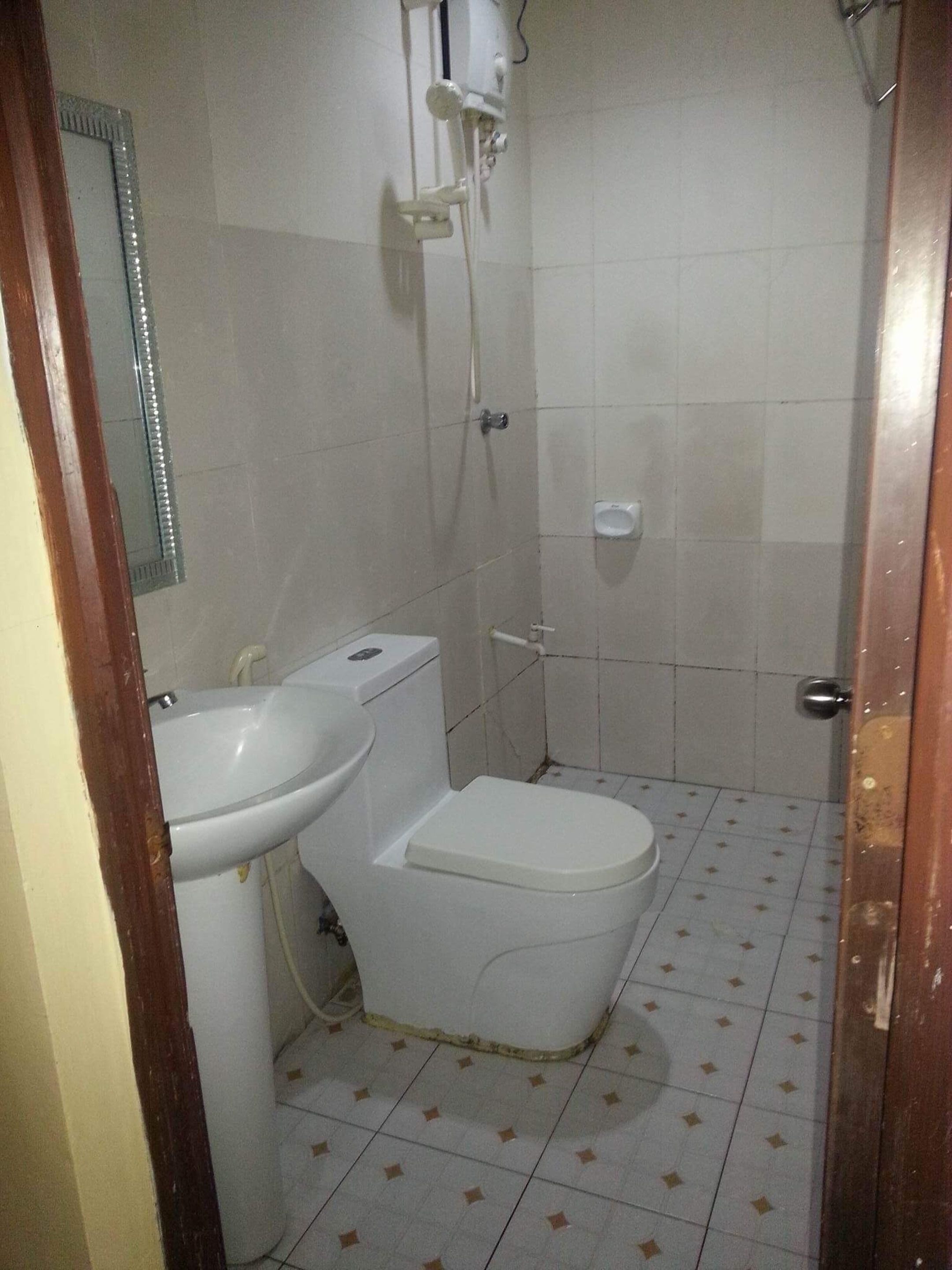 Un baño pequeño con inodoro, lavamanos y ducha.