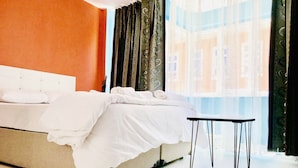 A hotel room with a bed, a small table, and a window with curtains. - Istanbul Harmony Hostel (Istanbul)