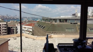 A rooftop view with a cityscape, including buildings and a body of water. - Istanbul Harmony Hostel (Istanbul)
